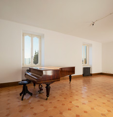 Empty room with antique piano and vintage heaters