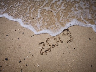 Happy New Year written on the beach