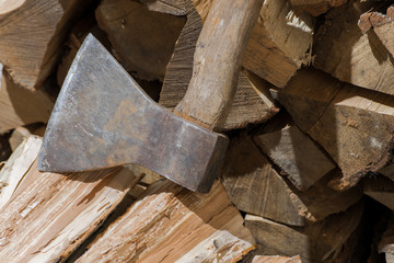 Rusty ax on a stack of firewood. Cutting wood for the winter