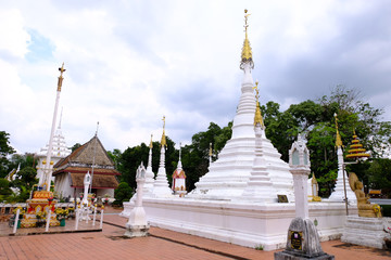 Naklejka premium The white Myanmar Pagoda in front of ancient Thai style ordination hall at Nonthaburi, Thailand December 2018