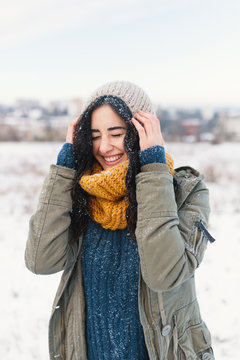 Smiling Woman Feeling Cold Snowflakes On Her Face During A Snow