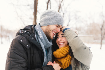 Happy young couple enjoying winter holidays laughing and hugging
