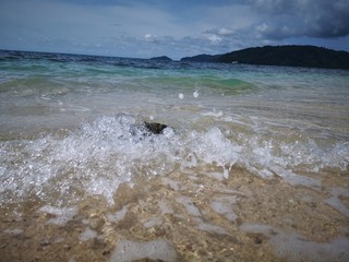 Beautiful wave breaks into the shore and created swash to the beach
