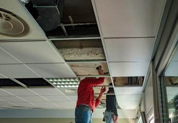 Builder putting or repairing up a suspended ceiling