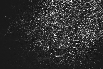 Dirty black wall close-up. Monochrome background with white sprays of dye. Black white texture of dark concrete wall with white spots. Painted backdrop in grayscale. Exfoliated paint. Flaking stucco.