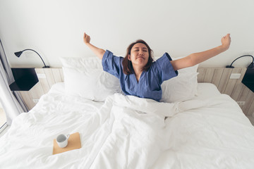 Asian girl Stretching the body after waking up in the morning. Make it brighter and with day activities. The concept of adequate sleep. Good sleep