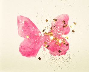 Golden glitter and glittering stars on pink watercolor butterfly in vintage nostalgic colors.