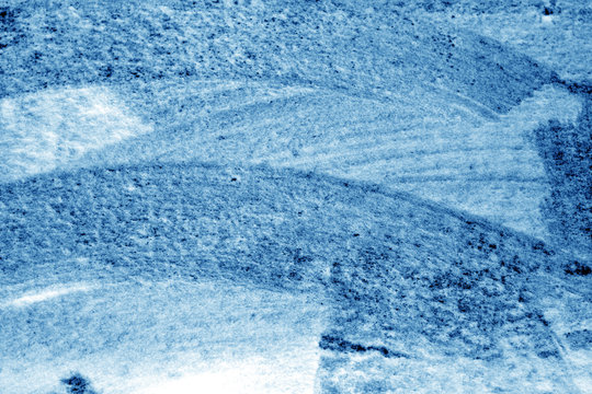 Snow surface on car glass in navy blue tone.