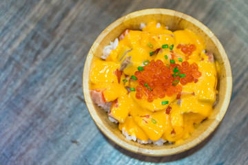 Bowl of sashimi rice and sauce topped with Ikura salmon roes. It is a formal Japanese meal and delicacy.