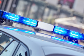 Fototapeta premium Police car with blue lights on the crime scene in traffic / urban environment.