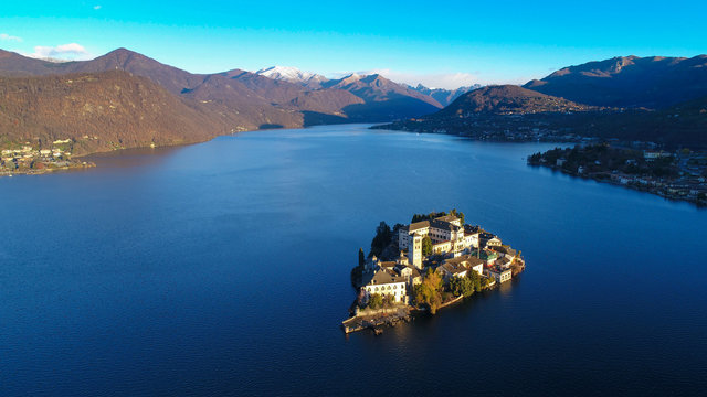 Aerial view of Lake Orta (Piedmont, Italy) with the San Giulio island at dawn on a sunny winter day.