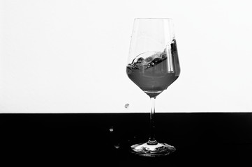 Black and white photo of red wine splashing out of a glass