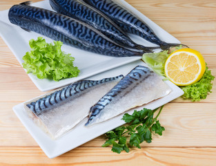 Salted Atlantic mackerel fillet against of raw fish carcasses