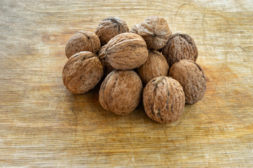 Pile of ripe organic walnuts lying on a wooden surface