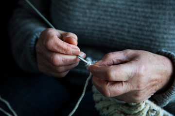 Close up of an older womens hands knitting a jumper