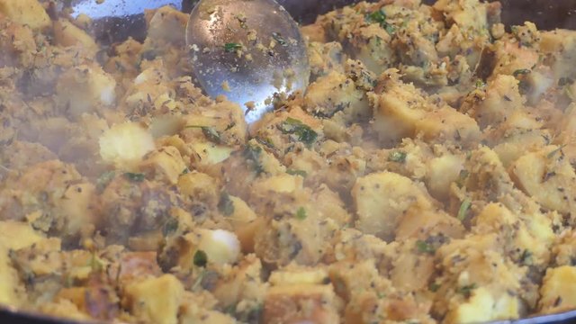 Freshly cooked pot of steaming potato and fenugreek leaves.