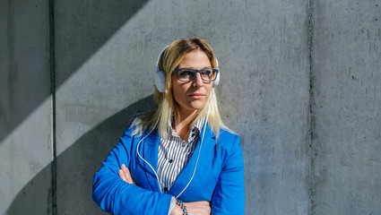 Obraz premium Businesswoman with headphones posing in the street