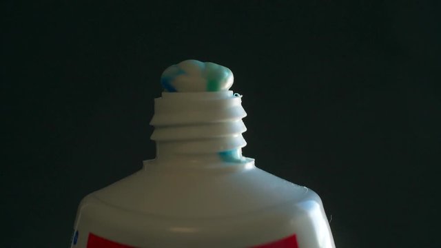 Squeezing toothpaste from tube slow motion closeup