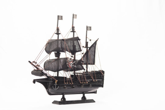 Black pirate boat model on white background. High resolution image.