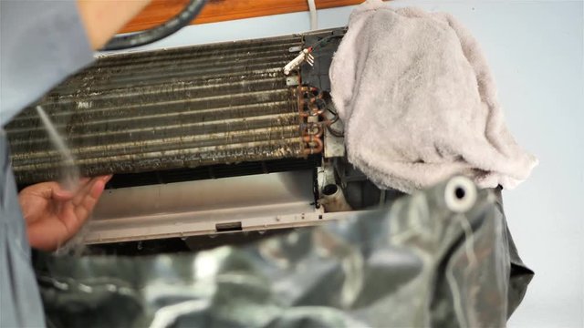 Male are repairman fixing and cleaning air conditioner unit by water in house. maintenance service. Slow Motion..