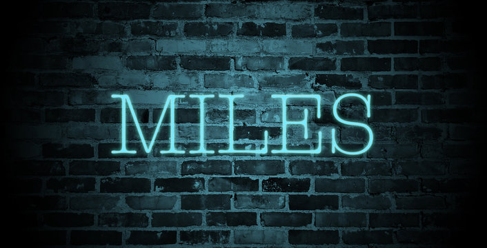 first name Miles in blue neon on brick wall