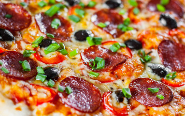 Pizza with Mozzarella cheese, pepperoni, tomato, pepper, olive, salami. Italian pizza on wooden table background