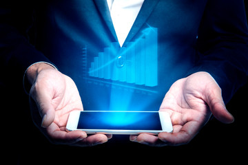 Businessman showing digital increases chart on hologram from mobile phone