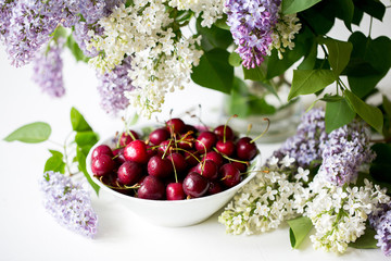 Morning. Spring season. Mood. Flowering lilac. Ripe sweet cherry.