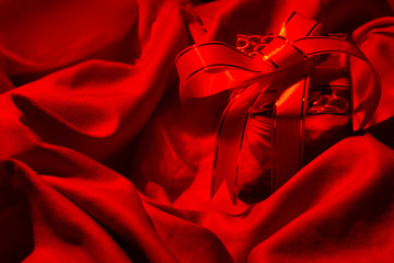Gift in red sheet bed fabric in valentine's day. A red gift box isolated on a romantic concept.