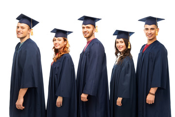 education, graduation and people concept - group of happy graduate students in mortar boards and bachelor gowns over white background