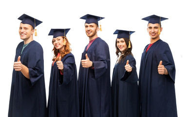 education, graduation and people concept - group of happy graduate students in mortar boards and bachelor gowns showing thumbs up over white background