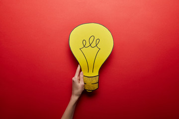 top view of yellow light bulb made from paper idea symbol on red background