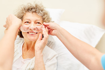 Frau als Patient bekommt Lesebrille