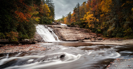 Triple Falls waterfall in fall color forest in the Appalachian mountains of North Carolina