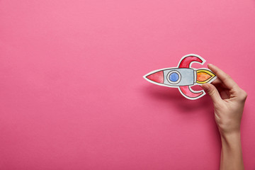 elevated view of flying rocket on pink background