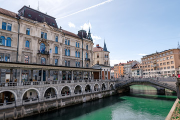 Fototapeta na wymiar Ljubljana in Slovenia on a cloudy day - River, bund, Ljubljana Castle