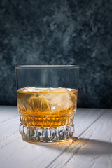 Glass of whiskey or rum with ice on concrete background with copy space for text, logo or brand. Bar concept. Close up view