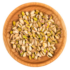 Pistachios in wooden bowl isolated on white background