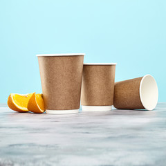 Brown  coffee cup on peach background. disposable paper dishes. Copy space for logo, text or brand