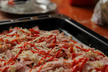 Pizza with all ingredients ready for baking. Homemade domestic pizza built on traditional way.