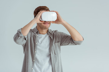 smiling man wearing virtual reality headset isolated on grey