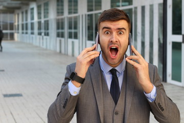 Surprised businessman with two cellphones