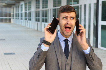 Stress out businessman with two cellphones 