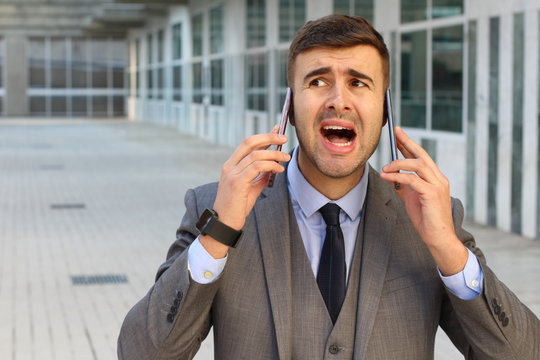 Overwhelmed businessman during double call  