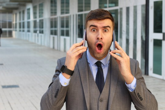 Surprised businessman with two cellphones