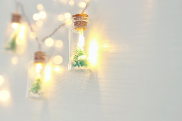 close up image of Christmas tree in the masson jar garland light over wooden white background.
