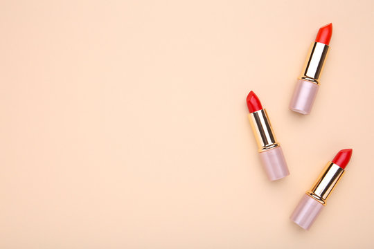 Red lipsticks on beige background, make up