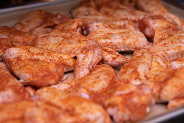 Chicken wings. Raw poultry meat with spices on a baking sheet