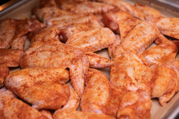 Obraz na płótnie Canvas Chicken wings. Raw poultry meat with spices on a baking sheet