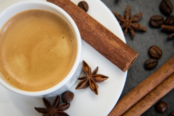 Coffee set. Espresso drink in white cup with cinnamon quills and star anise